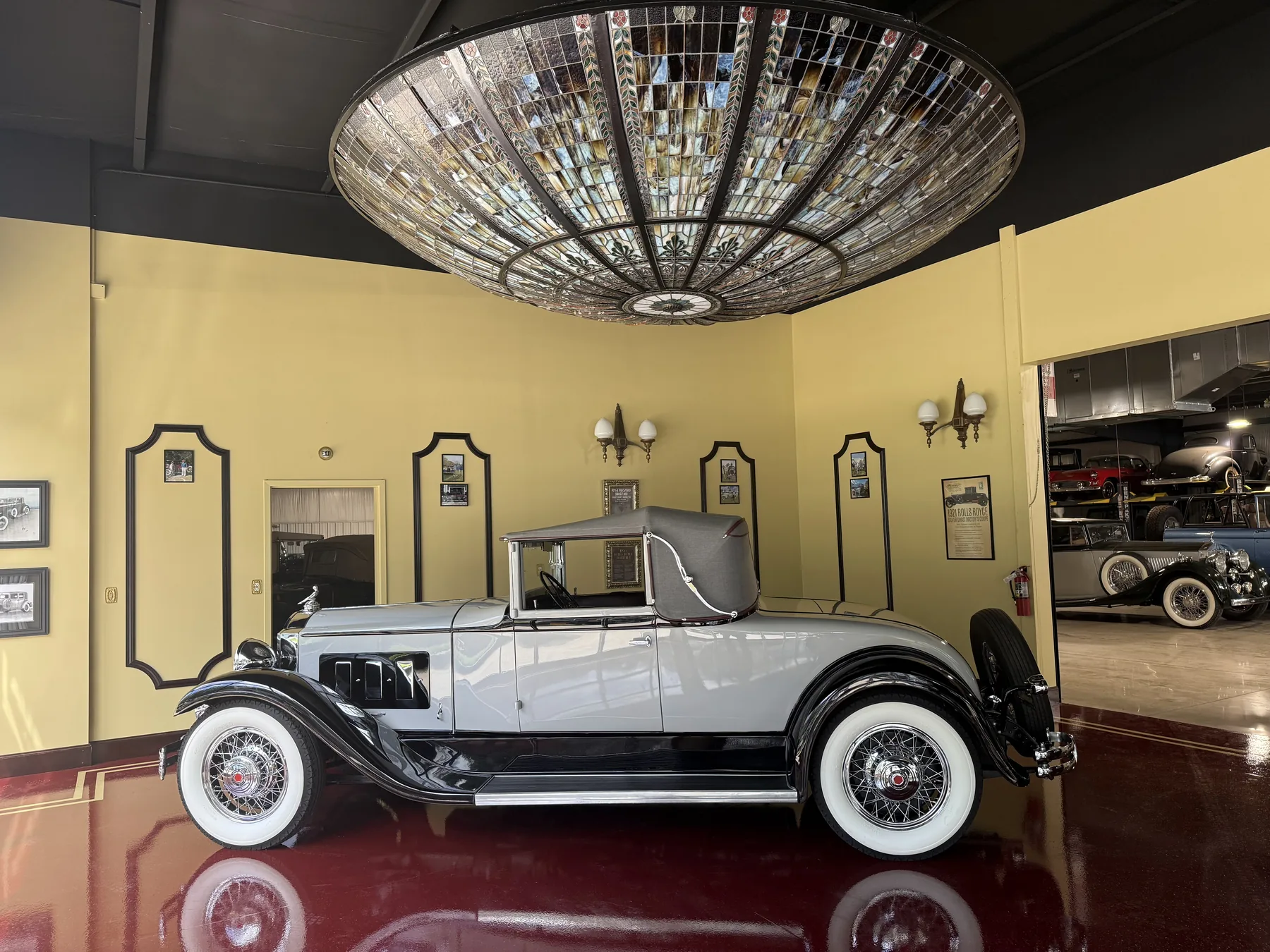 Ivory vintage motorcar displayed in a private showroom